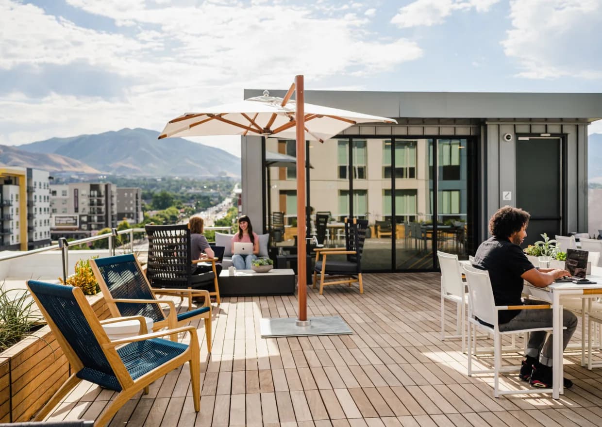 The Shop's rooftop patio with umbrellas, outdoor seating and the Wasatch mountains behind
